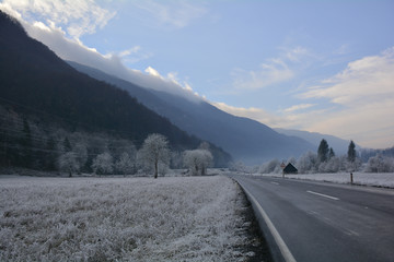 A road near Tolmin in Primorska, Slovenia, cutting through a landscape covered in hoar frost
