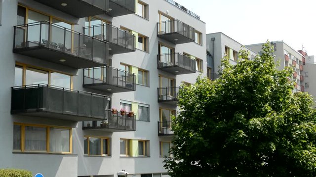 view of the modern prefab house in the suburb-hedge around the entrance sidewalk