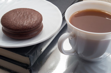 White cup of hot chocolate and a biscuit