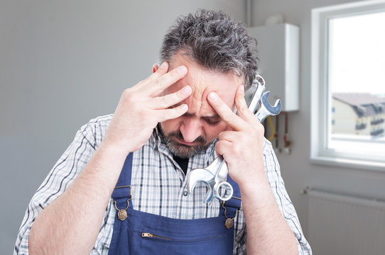 Sad male fitter having headache