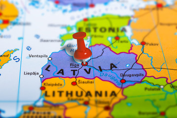 Riga Latvia pinned on colorful political map of Europe. Geopolitical school atlas. Tilt shift effect. - obrazy, fototapety, plakaty