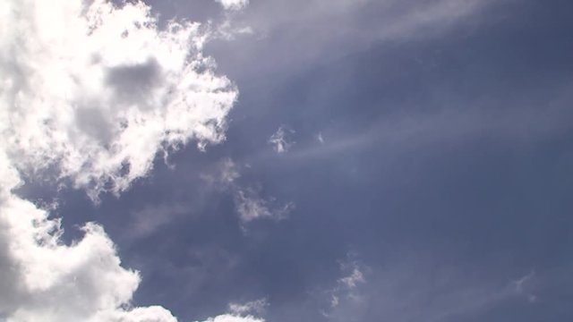 Rasch dahinziehende Wolken am blauen Himmel