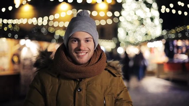 happy man in hat and winter jacket at christmas