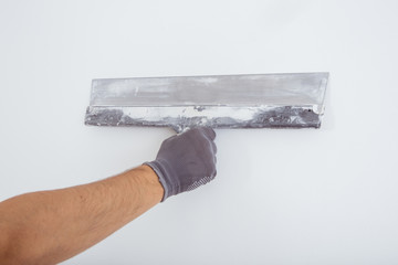 Man's hand in a gray glove with spatula
