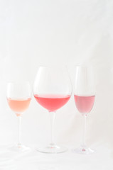 Three stemmed glasses with red and rose wine, vertical