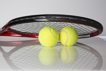 Tennis racket and two balls for playing tennis on a black background