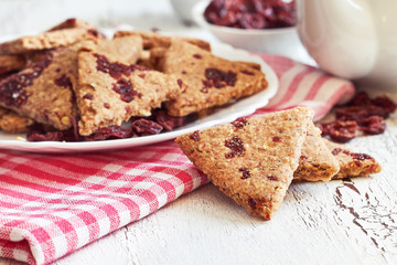 Whole wheat cookies with dried cranberries on white rustic wooden background