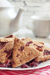 Whole wheat cookies with dried cranberries on white rustic wooden background