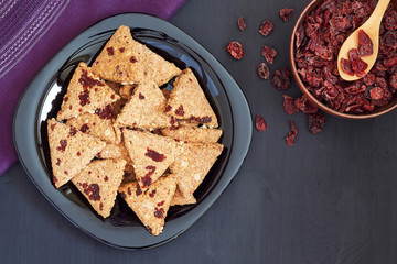 Whole wheat cookies with dried cranberries on black wooden background. Top view with copy space