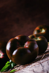 Large black tomatoes, rustic style, selective focus
