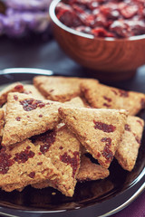 Whole wheat cookies with dried cranberries on black wooden background