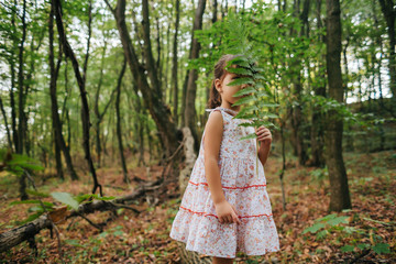 little girl in the forest with ferns