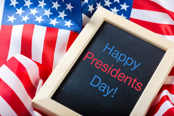 the text happy presidents day written in a chalkboard and a flag of the United States
