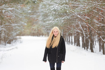 girl in the winter woods on a snowy road
