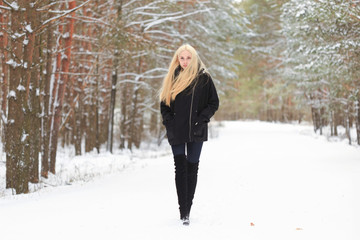 girl in the winter woods on a snowy road