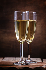 Glasses of champagne on the old wooden table, rustic style, sele