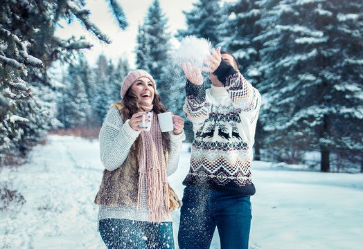 Couple Throwing Snow In Winter Forest