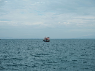 fishing boat in blue sea with clouds sky background in Thailand. Relaxing moments in summer seasons travel. Tropical nature in vacation time.