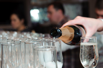 Waiter pours champagne in glasses