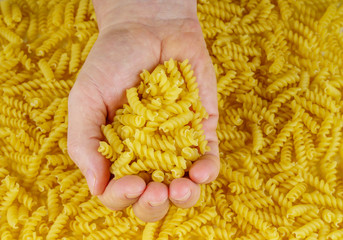 Hand holding fusilli noodles isolated