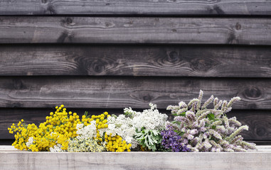 Fresh flowering herbs from garden, on a wooden rustic background
