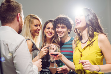 Happy friends having fun. Home party. Lot of confetti around them.