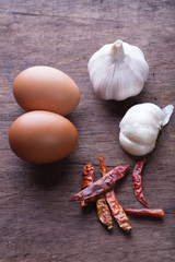 spice herb garlic chilli and egg on wooden background