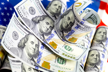 Hundred us dollar bills lying on the us flag