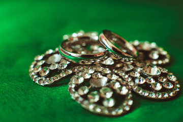 Beautiful golden wedding rings lying on barrette with stones