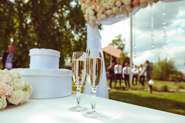 two glasses with champagne standing on the white table