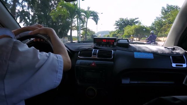 NHA TRANG, VIETNAM - NOVEMBER, 17, 2016: Taxi ride through the city. Taximeter in the foreground. Payment for the trip.