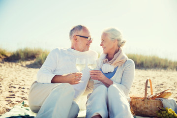 happy senior couple talking on summer beach