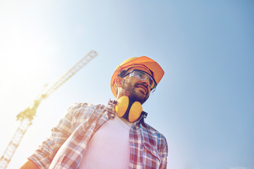 smiling builder with hardhat and headphones