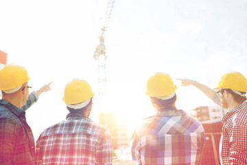 group of builders in hardhats at construction site