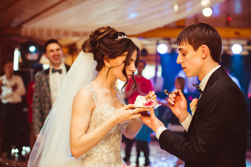 beautiful and young bride and groom tasted wedding cake
