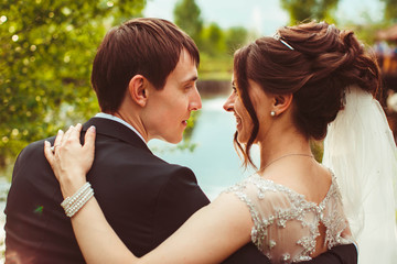 beautiful bride and groom hug each other outdoors