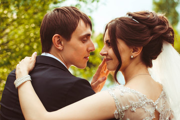 beautiful bride and groom hug each other outdoors