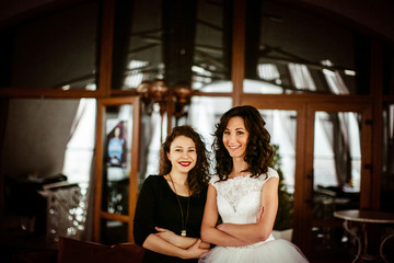 The bride with  bridesmaid stand in the restaurant