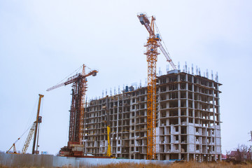 Concrete building in progress with cranes 
