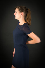 Fototapeta premium Beautiful woman doing different expressions in different sets of clothes: backache