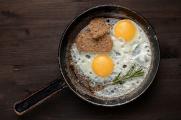 fried egg with rosemary on an old pan