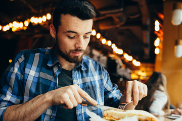 Handsome young man having lunch in elegant restaurant alone