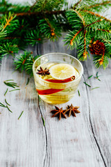 a mug of tea with lemon and cinnamon sticks star anise Christmas theme