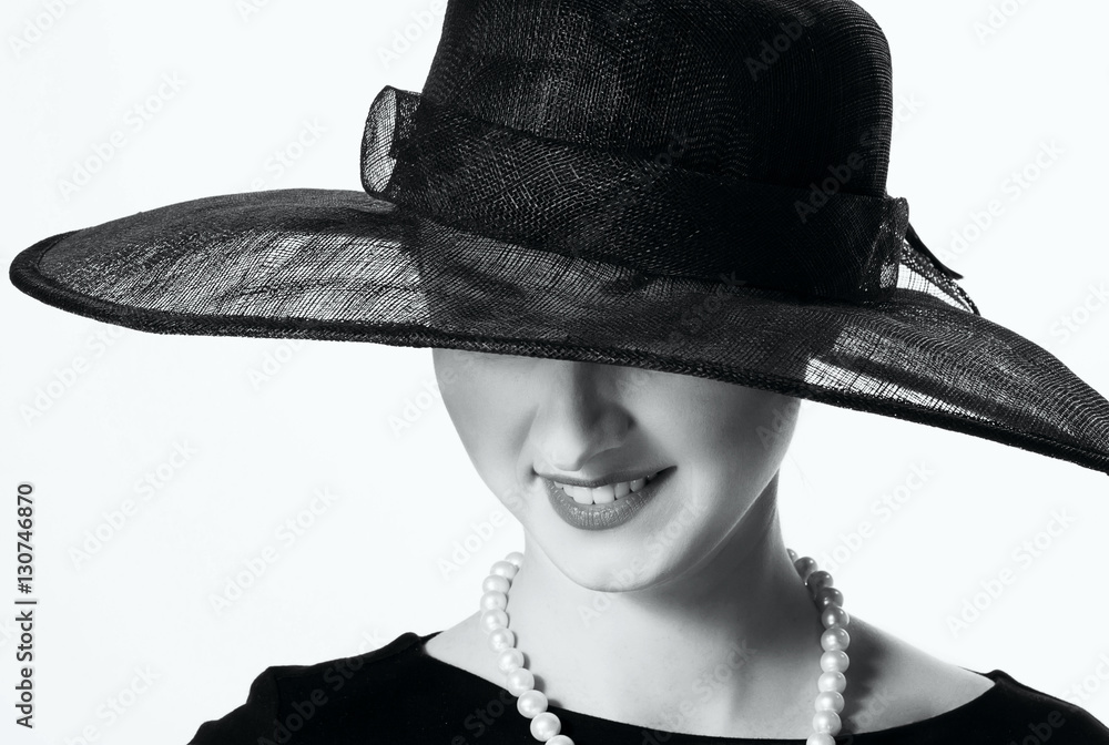 Wall mural close-up portrait of a beautiful woman in a black hat in retro s