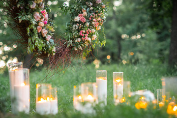 Wedding decor, candles in glass flasks in the forest