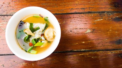 Soup in white bow put on wood background.
