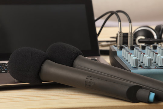 Two microphones with a laptop and an audio mixer. Sharpness on the near microphone. Close-up