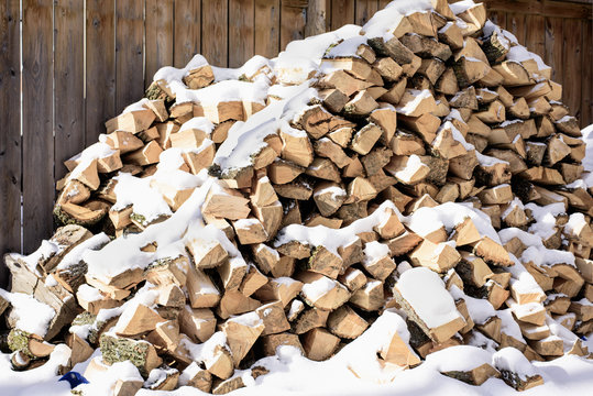 stacked firewood covered in snow