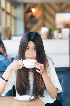 Happy asian female with latte coffee in cafe during free time