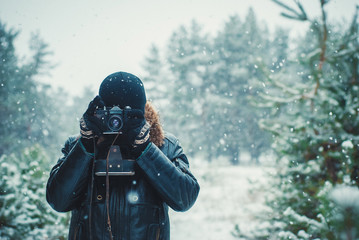 Young man with vintage camera outdoor. concept of winter photography